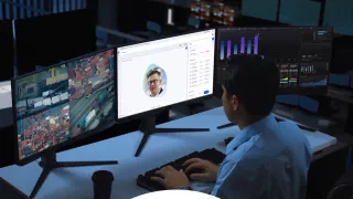 A man sitting in front of multiple computer monitors